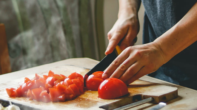 Cutting tomatoes on wood board