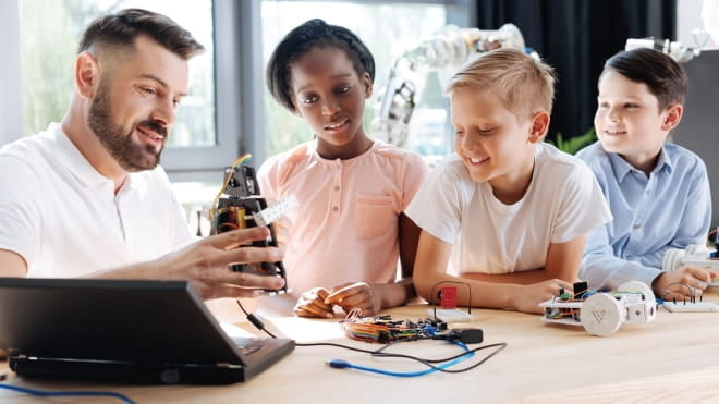 Man showing computer parts to children