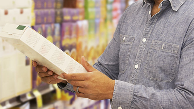 Man reading ingredients on food box