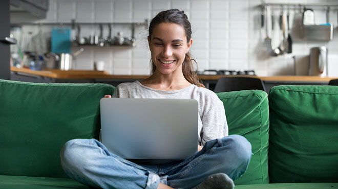 Sitting on sofa using laptop