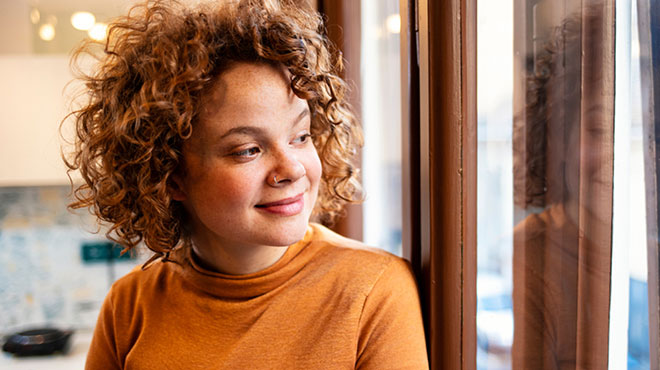 Woman's reflection on window as she is gazing outside