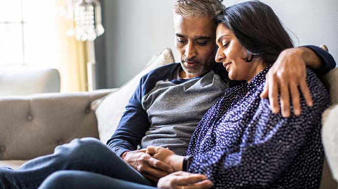 Couple on sofa holding hands