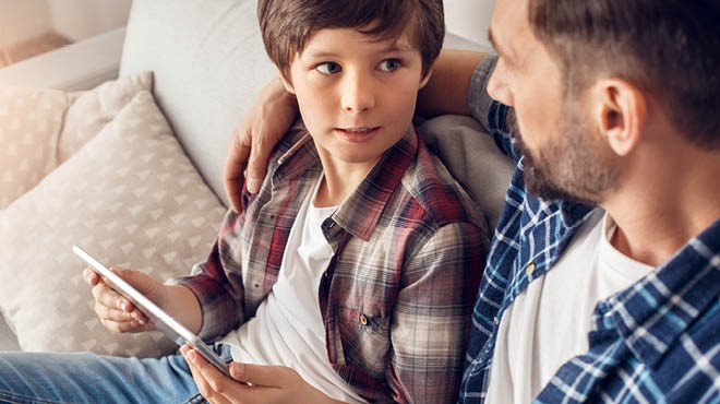 Dad and child sitting on sofa talking