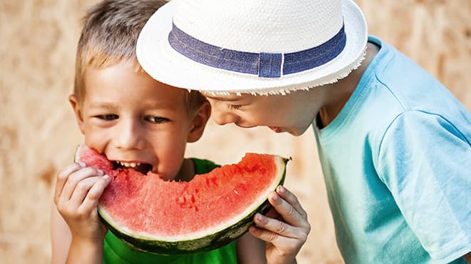 Two children eating watermelon