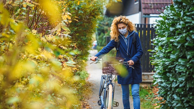 Walking bicycle on the sidewalk in fall