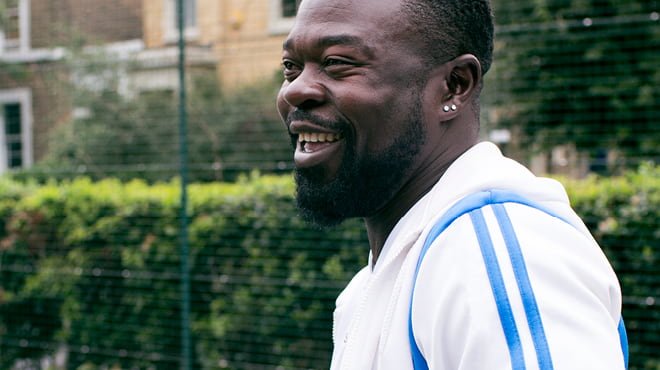 Bearded person wearing white shirt with blue stripes