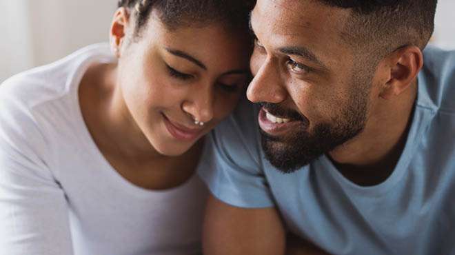 Couple, one leaning on shoulder of the other