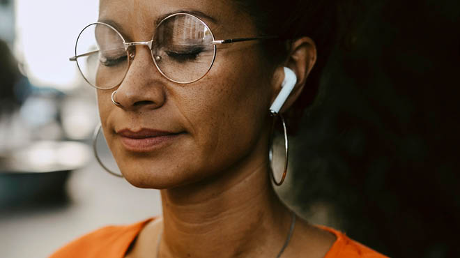 Eyes closed, wearing glasses. using airpods