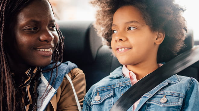 Kids seat-belted in the back seat of a vehicle