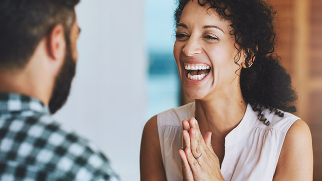 Laughing with hands together