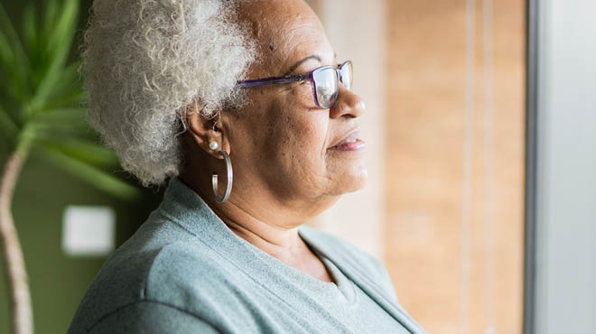 Person with short, curly grey hair, wearing hoop earrings