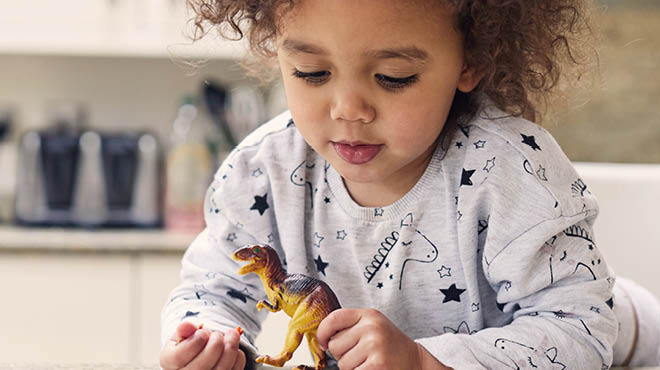 Toddler playing with dinosaur toy