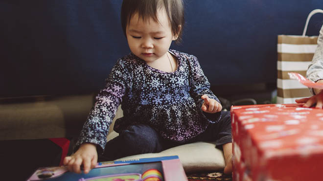 Toddler playing with gift