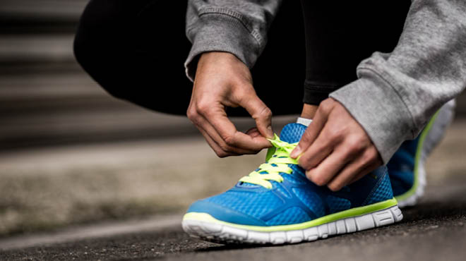 Tying green laces on blue tennis shoes