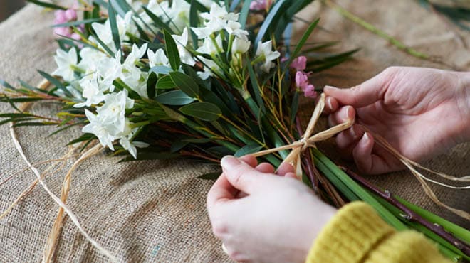 Tying raffia on flower bouquet