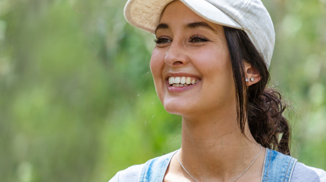 Person with ponytail wearing baseball style-cap