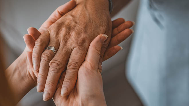 Hands holding hand with ring