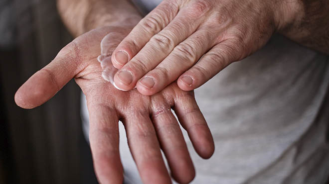 Hands spreading lotion