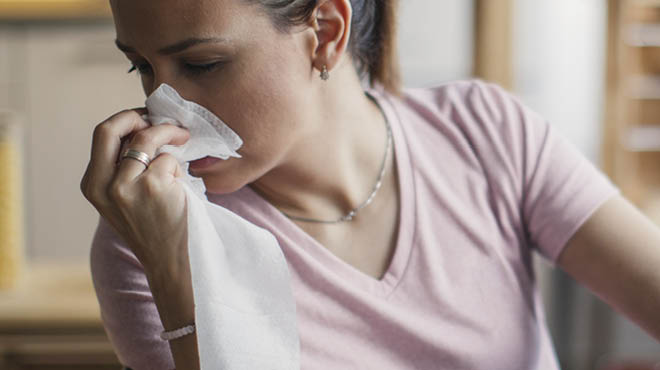 Holding tissue against nose