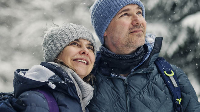 Two people looking up in sky in winter scene