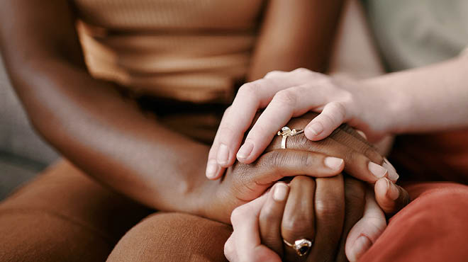 Two sets of hands clasped together