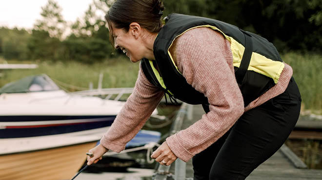 Wearing lifejacket bending on dock