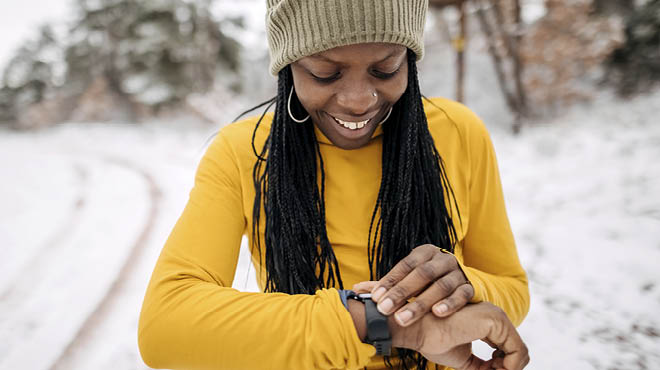 Adult wearing gold checking heart rate on wrist watch