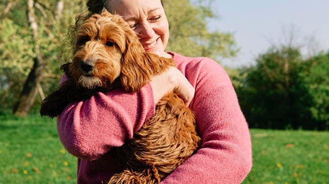 Holding dog outdoors