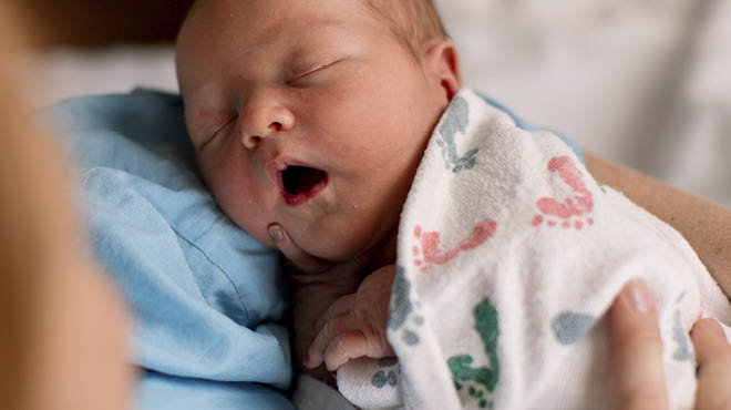 Infant being held while sleeping