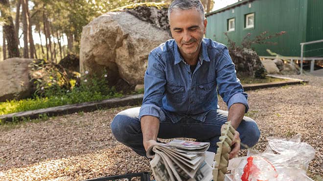 Man squatting holding recyclables