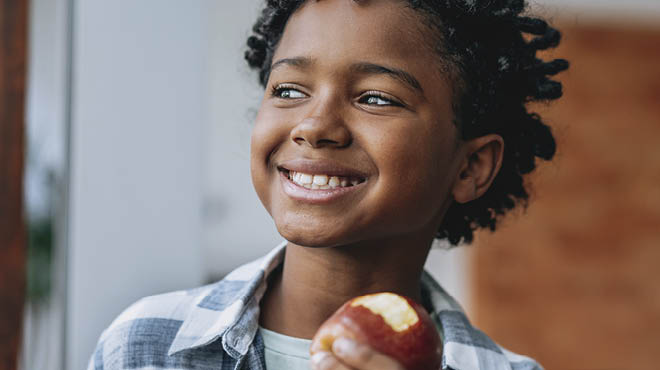 person holding bitten apple