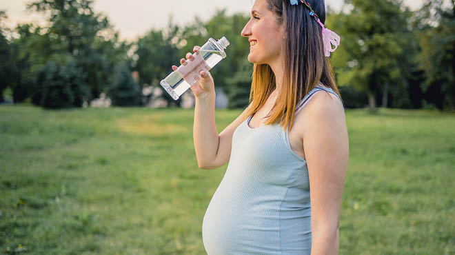 Pregnant person drinking water